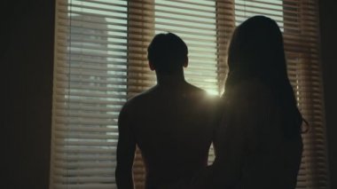 Pencerenin yanında kör bir adam dikiliyor bir kadın ona yaklaşıyor ve arkadan sarılıyor. Pencerenin dışında gün batımı. Mutlu çift birlikte..