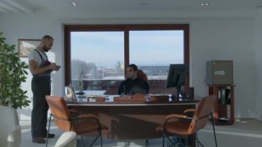 İşadamı bir ofis sandalyesinde otururken, nakliyeciler el konulan malları suçluyorlar. Hızlandırılmış çekim.