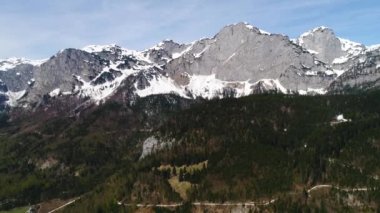Avustralya Alpleri 'nin karlı tepelerinde hava aracı görüntüsü. High Mountain Range 'den panoramik manzara. Mavi gökyüzü güneşli. Avrupa. Bahar. 4K video.