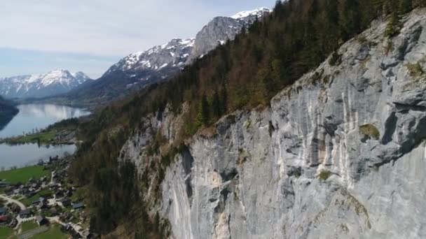 Paisagem aérea de alpes montanhas rochosas, pequena aldeia em alpes e belo Lago Grundlsee na primavera. Paisagem da aldeia austríaca, montanhas facilmente cobertas de neve e belo lago azul entre — Vídeo de Stock