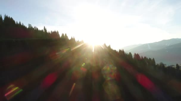 Montagnes alpines au coucher du soleil. Vue par drone du village autrichien et des sommets enneigés des Alpes au printemps. Forêt verte, champ, ciel blanc et journée ensoleillée. L'Europe. Vidéo 4K. — Video