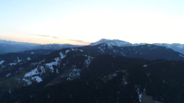 Avustralya Alpleri 'nin karlı tepelerini kolayca karla kaplayan güneş batıyor. High Mountain Range 'den panoramik manzara. Bahar günü, mavi gökyüzü. Avrupa. 4K video.