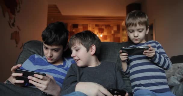 Kleiner Geschwisterjunge beim gemeinsamen Spielen auf dem Handy. Freizeit, Kinder, Technik, Internetkommunikation und Menschen-Konzept - lächelnde Jungen mit Smartphone-SMS oder Spiel zu Hause — Stockvideo