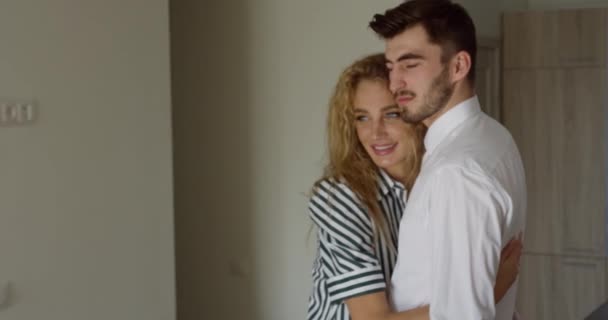 Atrakcyjna kochająca się para przytulająca się w nowym domu. rodzina młoda blondynka kobieta i młody brunetka mężczyzna. — Wideo stockowe