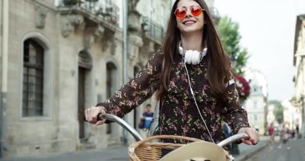 ヴィンテージスタイリッシュなマキシスカート暖かいカーディガンと藁帽子で彼女のヒップスターレトロバイクに乗ってエレガントな女性の屋外ファッションの肖像画。 — ストック動画