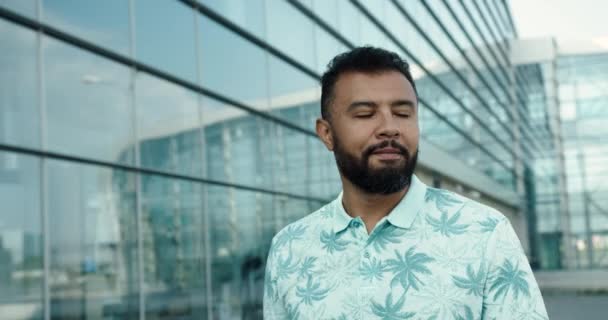 Close up retrato de belo jovem barbudo vestindo óculos de sol andando pela rua e sorrindo. Africano sendo um turista em uma cidade grande. — Vídeo de Stock