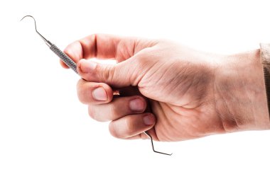 bir diş ölçekleyici tutarak