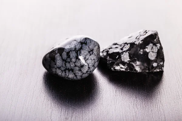 Obsidian stones on wood — Stock Photo, Image