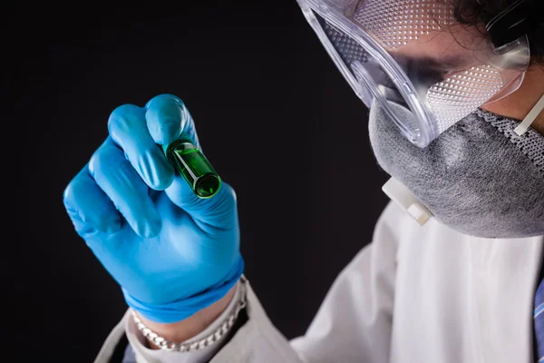 Researcher examining green vial — Stock Photo, Image