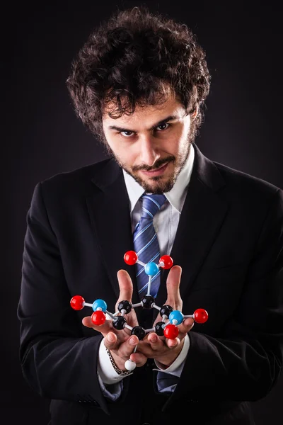 Hombre de negocios con una estructura atómica tnt — Foto de Stock