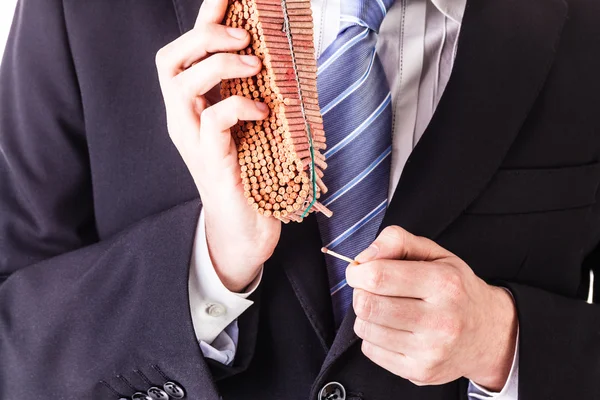 Businessman lighting firecrackers with match — Stock Photo, Image