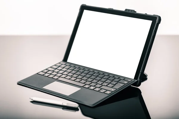 Ноутбук с ручкой на черной поверхности — стоковое фото