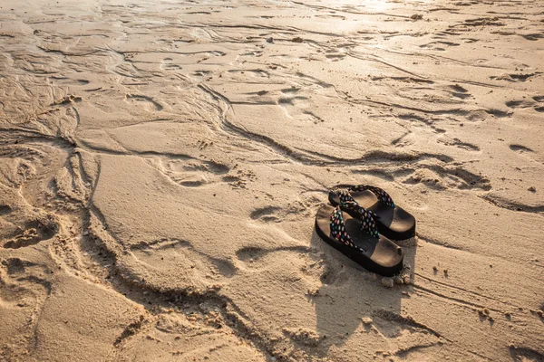 Flip flops på strandlinjen — Stockfoto