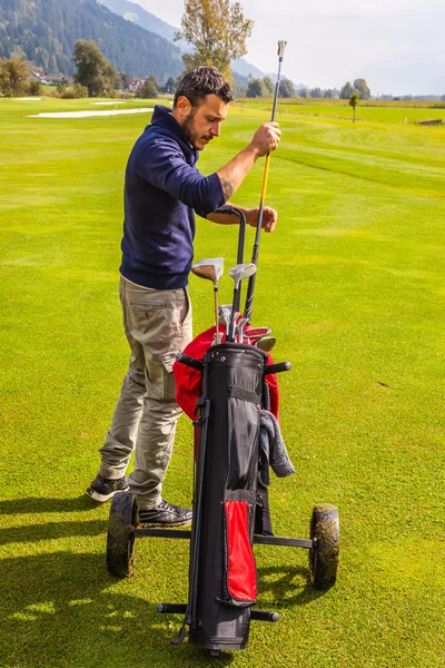 Jogador de golfe e seus tacos de golfe — Fotografia de Stock