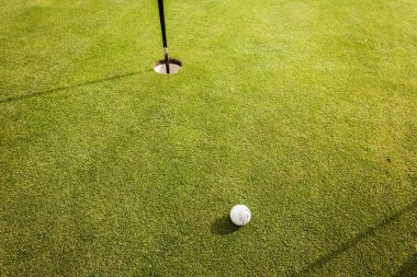 Golf topu deliğin yanında.