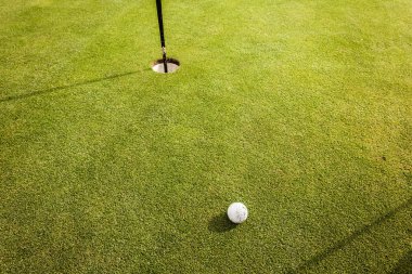 Golf ball near the hole clipart