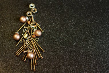 Noel ağacı şeklindeki vidalar, siyah parıltılı arka planda altın rengi parlak çelik cıvata, metin yeri, dükkan müşterileri için tebrik kartı 