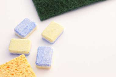 Mutfak süngerleri ve çamaşır makinesi tabletleri, beyaz üzerine sarı ve yeşil mutfak gereçleri ve sabun, izole edilmiş iç çamaşır aletlerini kapat