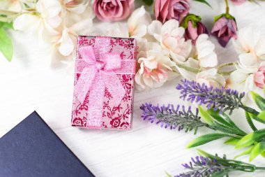 Sevgililer günü için romantik kompozisyon, düğün, doğum günü. Hediye kutuları, çiçekler, pembe kağıda sarılı kutu ve beyaz masa manzaralı gül lavantalı sakura çiçekleri.. 
