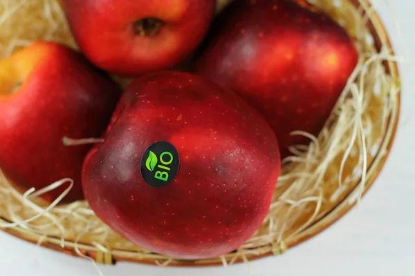 Red natural apple with bio sticker, apples harvest, agricultural raw fresh fruit in a basket on white background