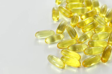 Sarı ilaç kapsülü, omega 3 hapları, E vitamini sağlık tedavisi, beyaz arka planda deri kılı bakımı için balık yağı.