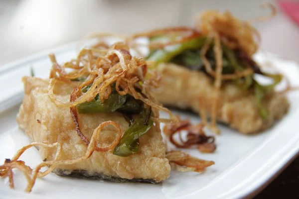 Morina balığı, soğanlı kızarmış bacalao, beyaz tabakta, ahşap masa geleneksel İspanya yemeği, kızartılmış yemek, Bask ülkesindeki sidreria mezesi 