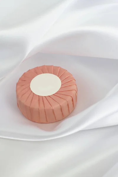 Στρογγυλή Μπάρα Σαπουνιού Ροζ Χάρτινη Συσκευασία Λευκό Μεταξωτό Φόντο — Φωτογραφία Αρχείου