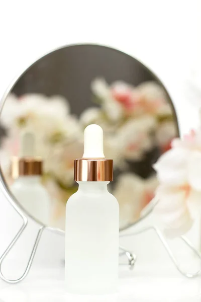 Matně Bílá Kosmetická Láhev Pipetou Bílém Květinovém Pozadí Zrcadlovým Odrazem — Stock fotografie