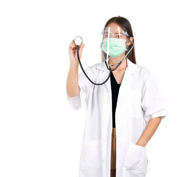 ガウンを着たアジアの女性医師は マスクとフェイスシールドを着用し 聴診器を保持し ポケットに片手を置きます スタジオライトと白の背景の肖像 — ストック写真