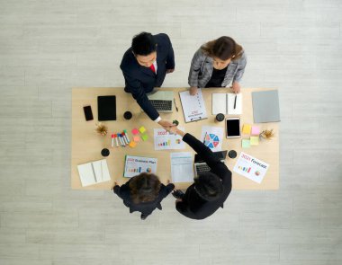 İş ortakları modern ofisteki toplantıda dizüstü bilgisayar, tablet, cep telefonu ve kahve ile tokalaşıyorlar. Kurumsal iş adamları konsepti. Üst Görünüm