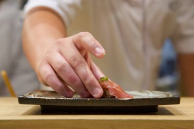 Seramik tabakta servis edilen taze wasabi ile ton balığı suşisi. Japon suşi restoranında Omakase deneyiminin tadını çıkarın..