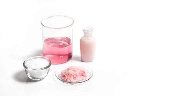 Pembe taneli kimyasallar, Potasyum Permanganat Sıvısı ve Cetyl esters beyaz laboratuvar masasına balmumu..