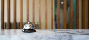 Otel resepsiyonundaki gümüş servis çanının yakın çekimi..