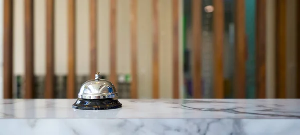 Otel resepsiyonundaki gümüş servis çanının yakın çekimi..