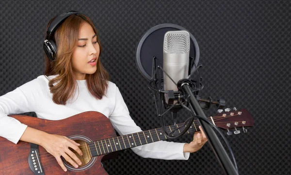 Joven Mujer Asiática Con Auriculares Cantando Mientras Toca Una Guitarra — Foto de Stock