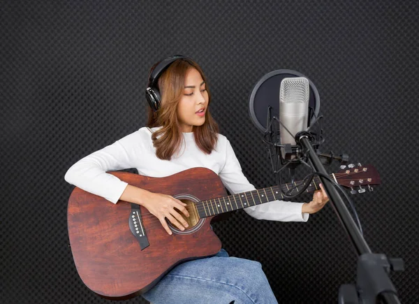 Joven Mujer Asiática Con Auriculares Cantando Mientras Toca Una Guitarra — Foto de Stock
