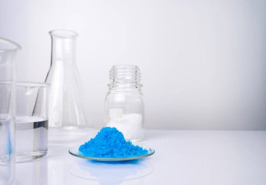 Beyaz laboratuvar masasındaki inorganik kimyasalları kapatın. Bakır (II) sülfat, mikro kristal balmumu ve alkol. Kozmetik ve Tuvalet ürünleri için kimyasal malzeme.