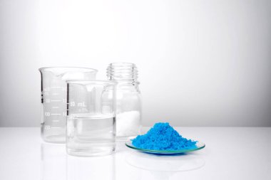 Beyaz laboratuvar masasında inorganik kimyasallar. Mikrokristal cila, Bakır (II) sülfat, alkol. Kozmetik ve Tuvalet ürünleri için kimyasal malzeme.