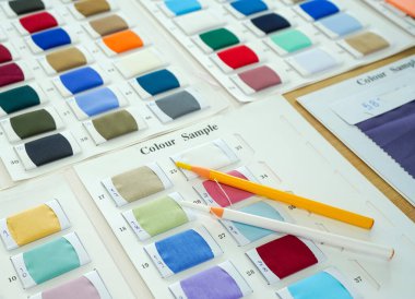 Parlak renkli kumaş örneklerine Mark Kalem Terzisi Tebeşiri dikiyorum. Terzinin dükkanında sabah atmosferi.