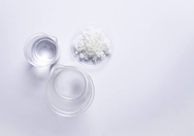 Şişede kristal berrak sıvı, Kimyasal Saat bardağında gevrek tuz. Laboratuvar masasında kimyasal maddeler var. Üst Görünüm