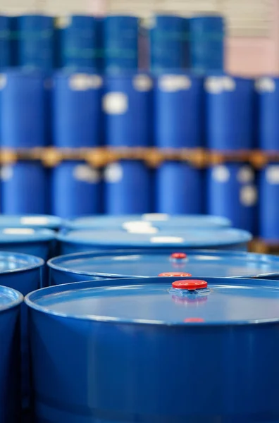 Red cap on blue chemical barrels.  Many barrels line up in the  background.