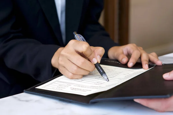 Closeup Hotel Manager Hand Holding Pen Pointing Guest Registration Document — Stock fotografie