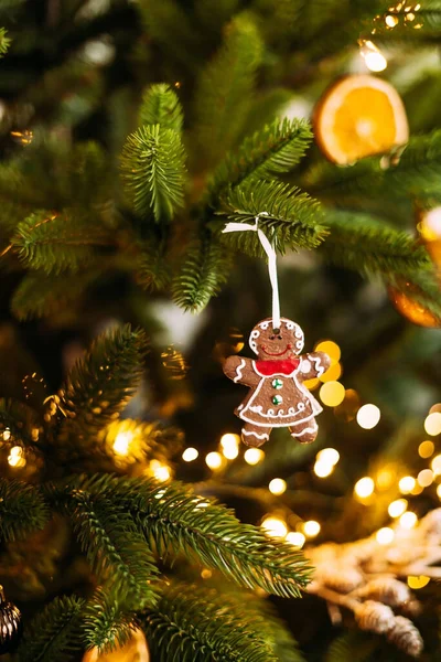 Vertikal foto pepparkakor kaka i form av en man väger på en julgran med bokeh ljus dekoration. — Stockfoto