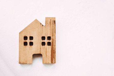 Beyaz arka planda küçük tahta ev oyuncağı. 