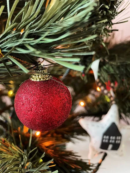 Röd glänsande boll hänger på granen närbild. — Stockfoto