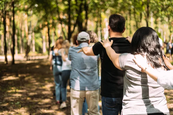 Teambuilding oefening. Mensen staan achter elkaar en houden hun schouders met hun handen vast.. — Stockfoto