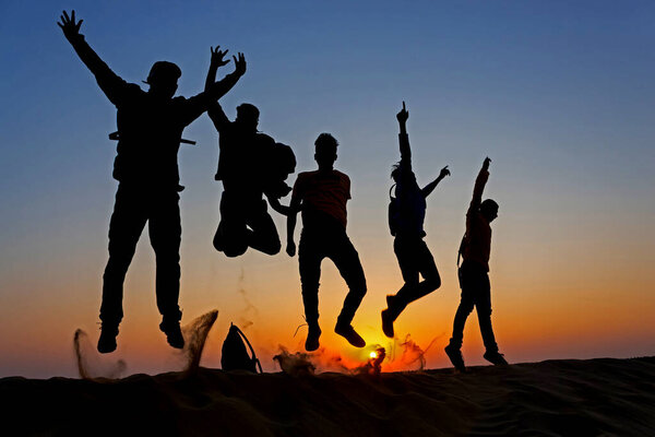 10 Nov 2020 Thar desert, Jaisalmer, Rajasthan, India. Silouette of friends jumping on the sand in Thar desert