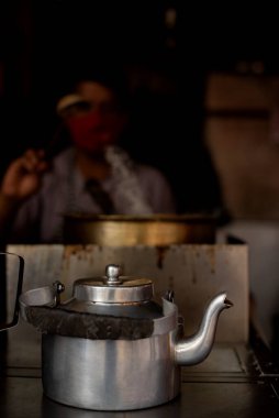 Satıcının bulanık resimli sıcak çay demliği de aynı şeyi yapıyor.