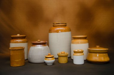 Kahverengi arka planda geleneksel seramik kavanozların çeşitliliği