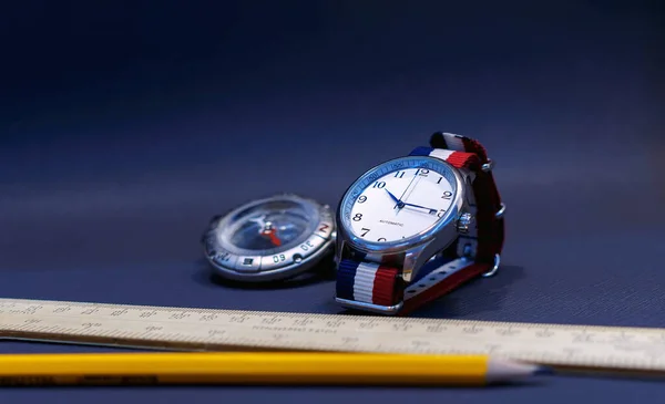 A pilot watch with watch strap as French flag on a dark gray background.